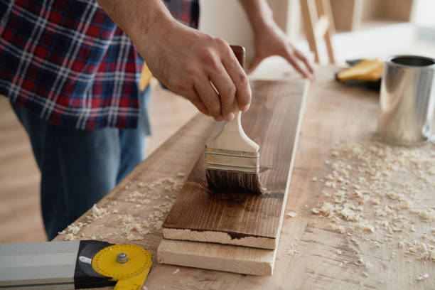 istock Man painting boards with a brush 1289050031