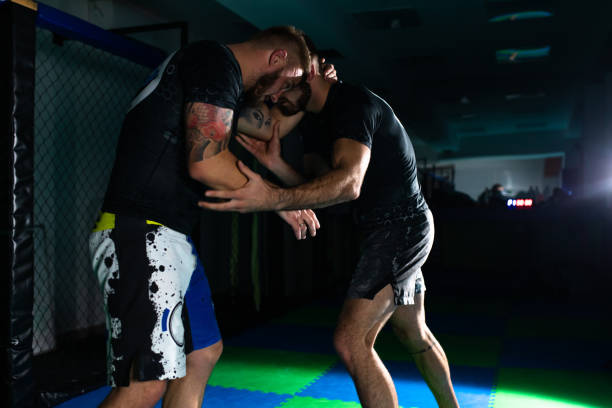 어두운 체육관에서 격투 연습 - mixed martial arts combative sport jiu jitsu wrestling 뉴스 사진 이미지