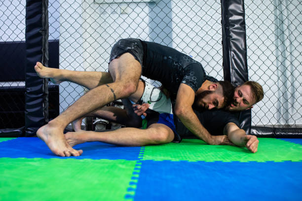 istock An MMA fighter pinned against a wire-mesh fence 1289051335
