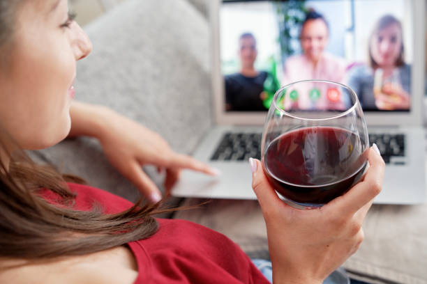 istock Woman drinking wine during video conference with friends 1289051591