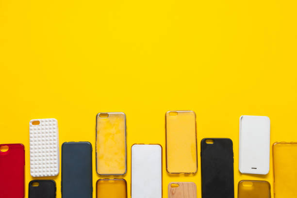 istock Pile of multicolored plastic back covers for mobile phone. Choice of smart phone protector case accessories background. Silicone phone backs on yellow background 1289052732