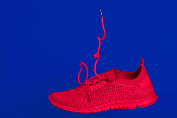 bright red running shoes levitate against a blue background