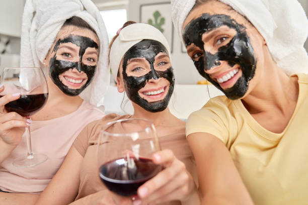 istock Three smiling friends taking selfies with face masks on faces 1289056371