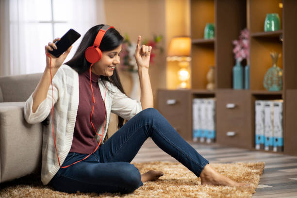 mujer joven en casa - foto de stock - attractive female only young women music living room fotografías e imágenes de stock