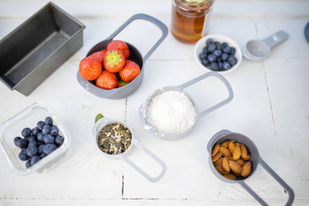 istock Berries, flour, and nuts in containers above white counter 1289059334