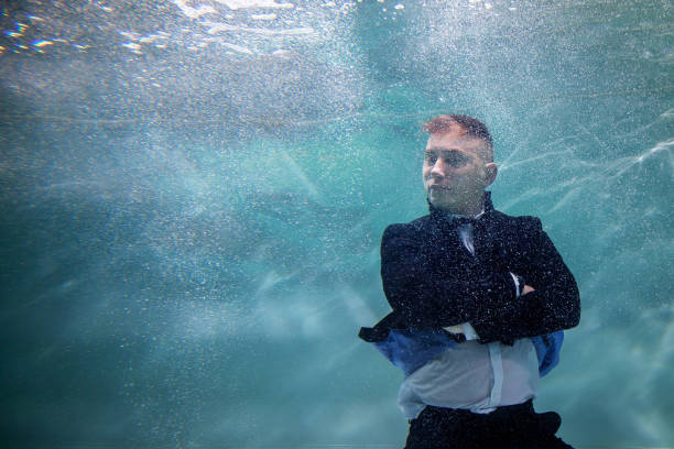 istock Young businessman folded his hands and strictly looks towards underwater 1289059431