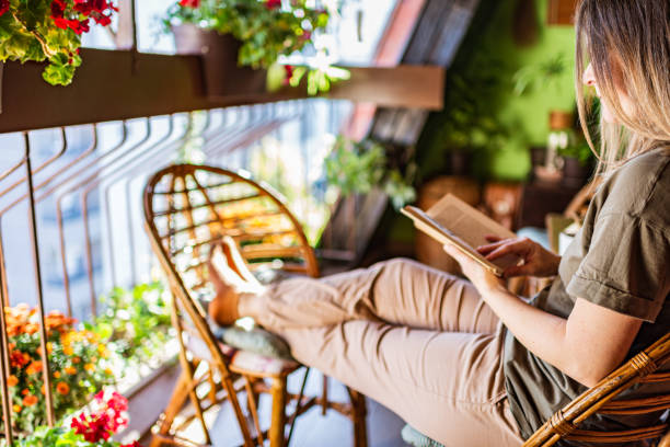istock Woman reading a book on a terrace 1289060318