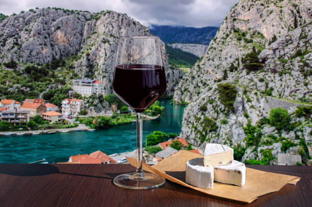 бокал красного вина с сыром бри на красивом горном фоне и реке в хорватии - makarska riviera стоковые фото и изображения