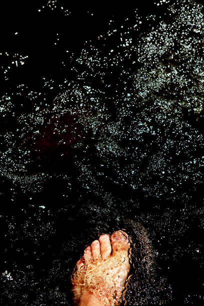 Pedicure on the feet. Well-groomed toenails. Black nail polish. Moisturizing the skin of the feet.