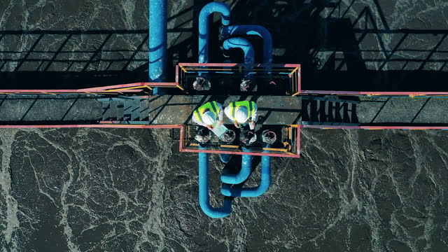 Top view of two wastewater operators working at a wastewater treatment facility
