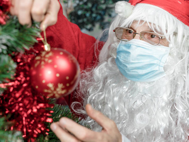 istock santa claus in protective face mask decorate christmas tree online lockdown concept 1289062309