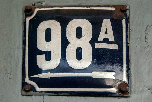 Weathered grunge square metal enameled plate of number of street address with number 98 A