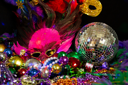 Mardi Gras or Rio Carnival masks and colorful carnival decorations.  Scene includes Feathered mask and party reflection ball.