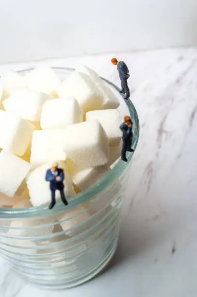 Conceptual sugar cubes in glass and businessmen diabetes conceptual metaphor
