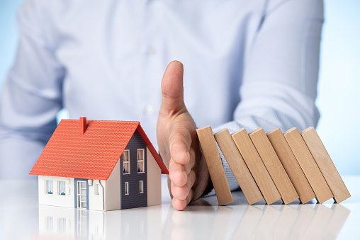 Businessman Hand Stopping The Wooden Blocks From Falling