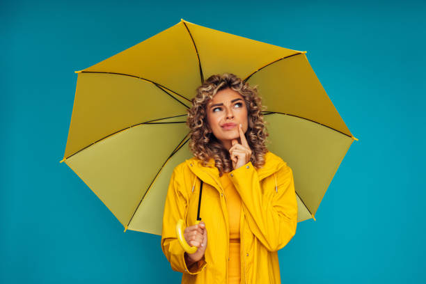 istock Girl holding yellow umbrella 1289069341