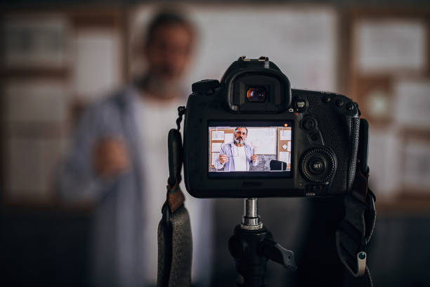 istock Camera filming male teacher lecturing students online during isolation period 1289071816