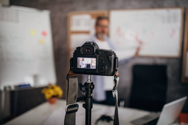 istock Camera filming male teacher lecturing students online during isolation period 1289071867