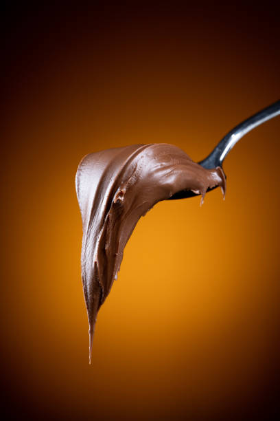 istock Cream chocolate in spoon on dark background 1289074791