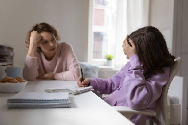 istock Unhappy girl child study at home with mom 1289074870