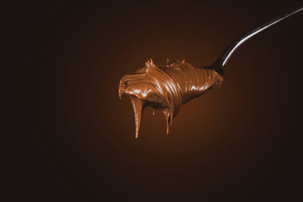 istock Cream chocolate in spoon on dark background 1289074906