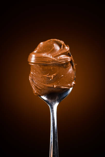 istock Cream chocolate in spoon on dark background 1289074963