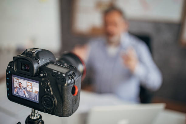 istock Camera filming male teacher lecturing students online during isolation period 1289075786
