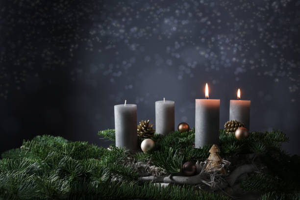 istock Second advent with two burning candles on fir branches with Christmas decoration against a dark grey background, copy space 1289076583