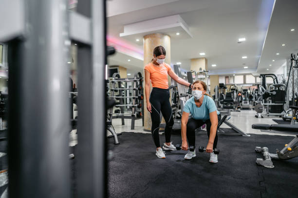 istock Senior woman doing crunches with trainers help 1289077448