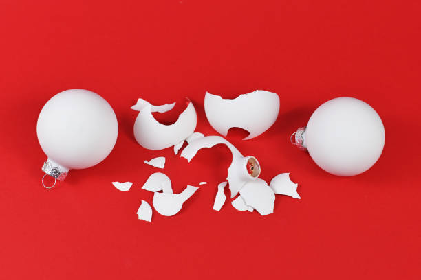 istock Shattered Christmas tree glass bauble broken into many pieces on red background 1289078363