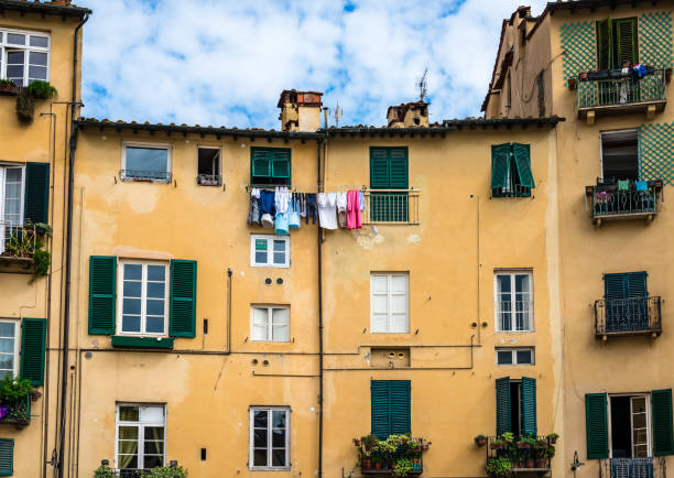 View of old houses with shutter windows in Piazza dell'Anfiteatro, in the center of the historical medieval town of Lucca, Tuscany, Italy.