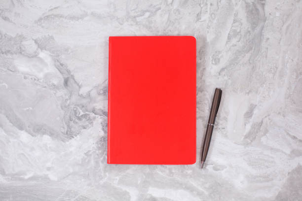 istock Red Notebook on on Gray marble. education concept 1289080815