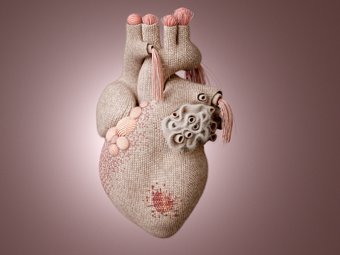 A knit heart with knitting decoration and visible mending