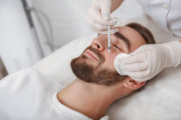 Handsome man getting facial skincare treatment at salon Beautician injecting filler into facial wrinkles of male client fillers stock pictures, royalty-free photos & images