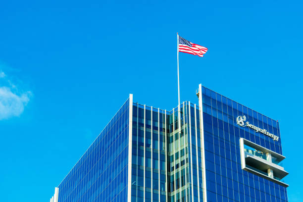 Sempra Energy corporate headquarters building facade. U.S. Flag proudly waving atop energy infrastructure company office under blue sky - San Diego, California, USA - 2018