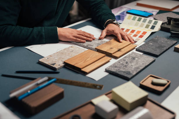 mani di un interior designer anonimo maschile che confronta campioni di materiali diversi nel suo ufficio - fabric swatch immagine foto e immagini stock
