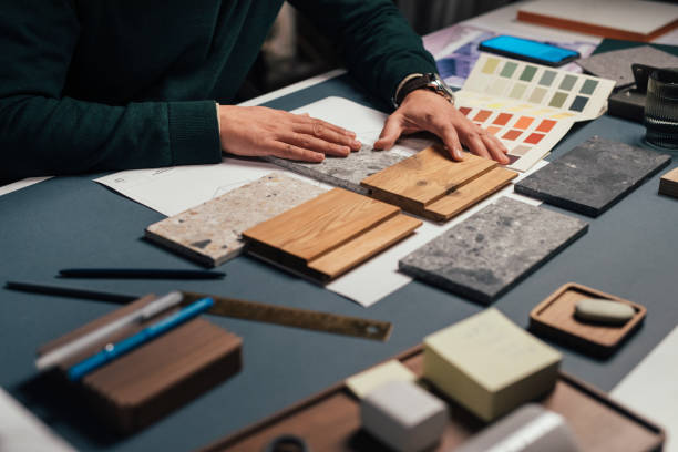 Hands of an Anonymous Male Interior Designer Comparing Samples of Different Materials in his Office