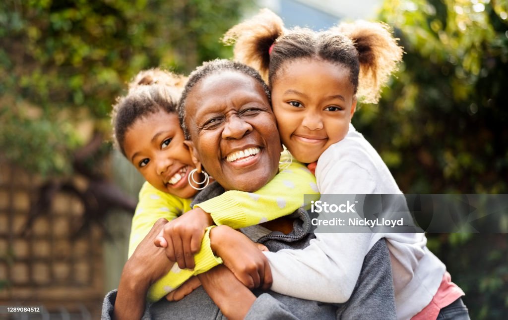 I love my grandchildren! Senior woman cuddling her two granddaughters outdoors Family Stock Photo
