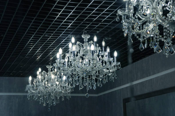 istock Large crystal chandeliers with candle-shaped light bulbs on a dark background 1289086865