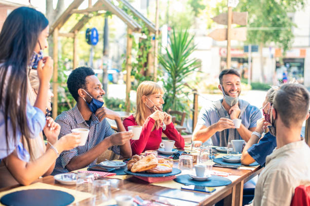 istock Friends group drinking cappuccino at coffee bar - People having fun together at cafeteria with face masks - New normal concept with happy guys and girls at restaurant cafe - Focus on black guy 1289087714