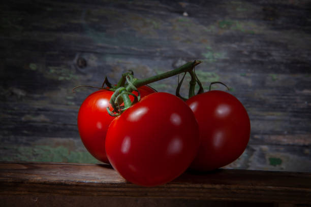 istock Three Shinny Vivid Red Tomatoes on Table 1289087876