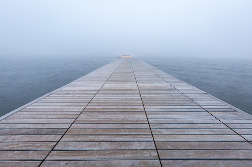 A pier in the fog leading into the distance