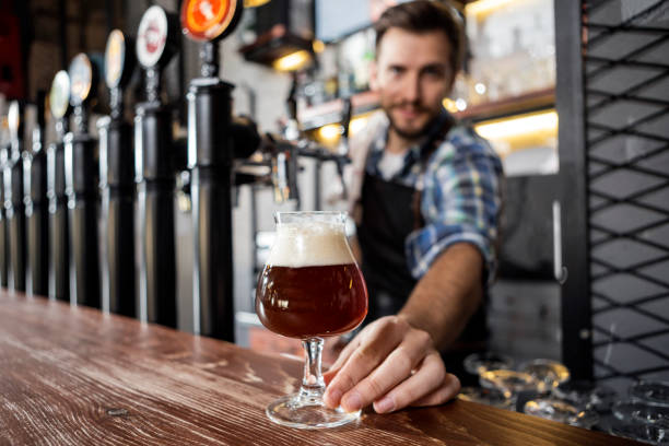 istock Man serving beer at a pub ,beer glass in focus 1289089789
