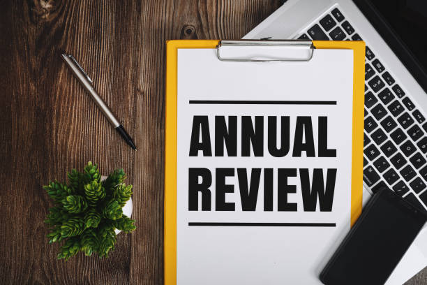 Annual Review on Clipboard Annual Review on Clipboard over Wooden Work Desk annual event stock pictures, royalty-free photos & images