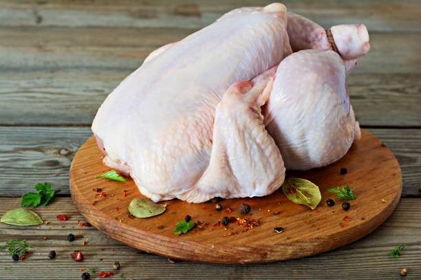 istock Raw chicken carcass ready for cooking on a cutting board on wooden background. 1289092500