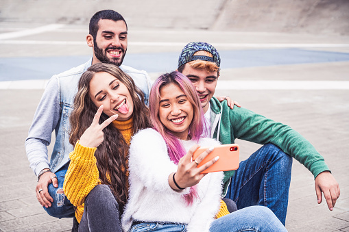 Felices amigos adolescentes multirraciales sonríen mientras se toman un selfie en la calle de la ciudad - Nuevo concepto de estilo de vida normal con jóvenes estudiantes divirtiéndose juntos cerca del campus photo