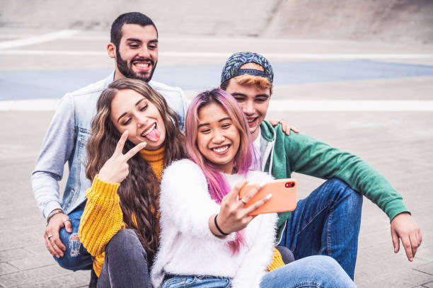 gelukkige multiraciale tienervrienden glimlachen terwijl het nemen van een selfie in de stadsstraat - nieuw normaal levensstijlconcept met jonge studenten die pret samen dichtbij aan de campus hebben - generatie z stockfoto's en -beelden