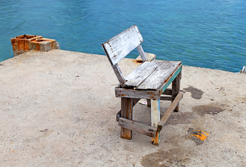 An old makeshift wooden chair near the sea.