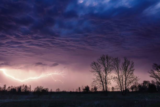 istock Heavy storm over the meadow, dark cloudy sky motion blur and lightning 1289094816