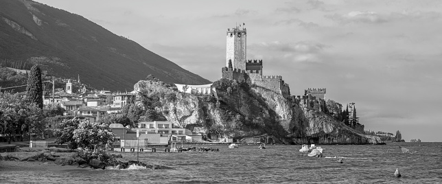 Malcesine - The beach of Lago di Garda lake with the town in the background.